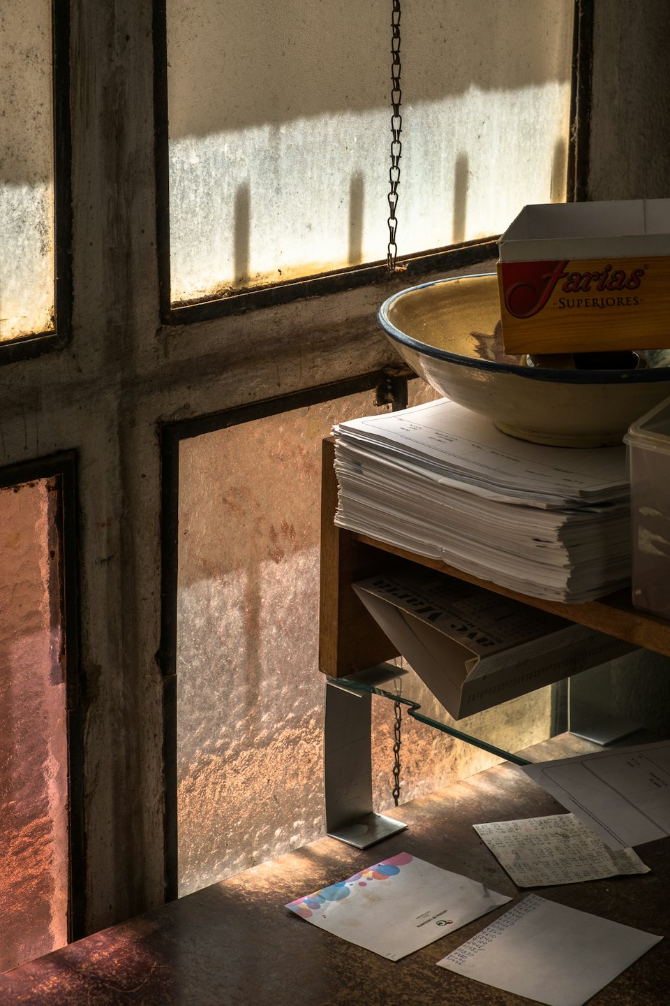 Cluttered wooden desk with papers, cigar box, and envelopes.